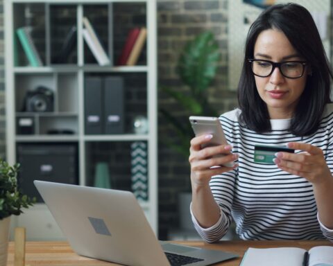 a woman sitting at a table looking at her cell phone
