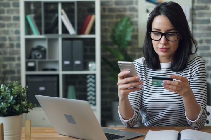 a woman sitting at a table looking at her cell phone