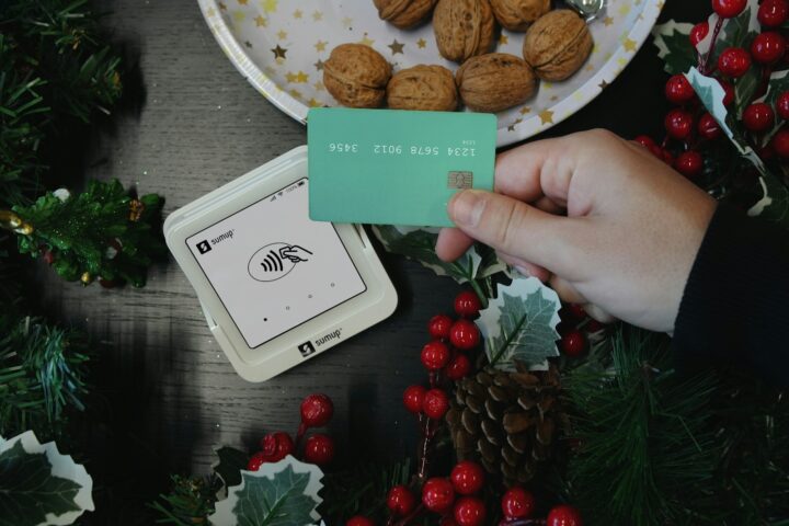 A person holding a card next to a plate of cookies